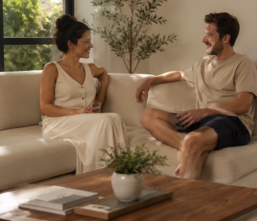 Two people relaxing on a sofa in a cool, calm living room